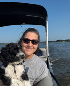 Sally on a boat with her dog.
